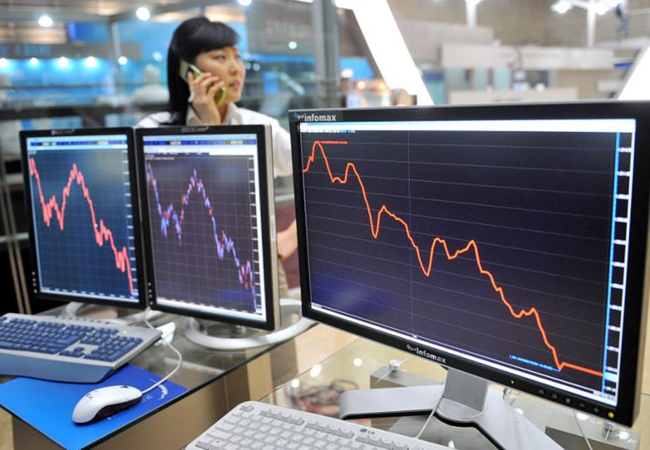  A woman in Seoul, South Korea, talks over her phone as computer screens show the Korea Stock Exchange collapsing during the financial crisis of 2008. Jung Yeon-Je/AFP 